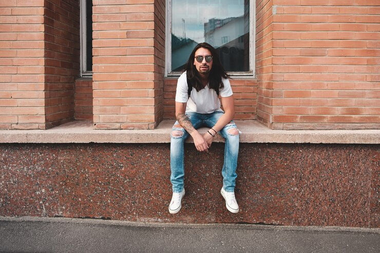 man in ripped jeans and sneakers