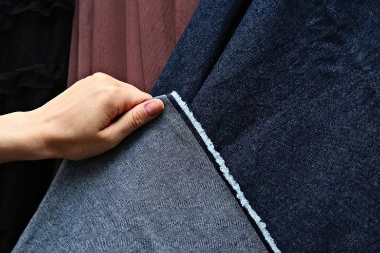 hand holding denim fabric to show texture